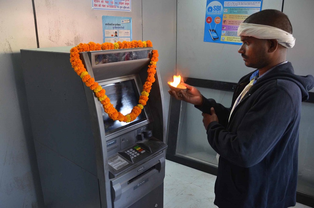A man offering puja to an ATM machine in Mirzapur. Photo: UNI