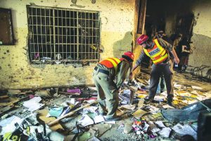 A rescue team goes through the debris inside Army Public School in Peshawar after a terrorist attack. Photo: UNI