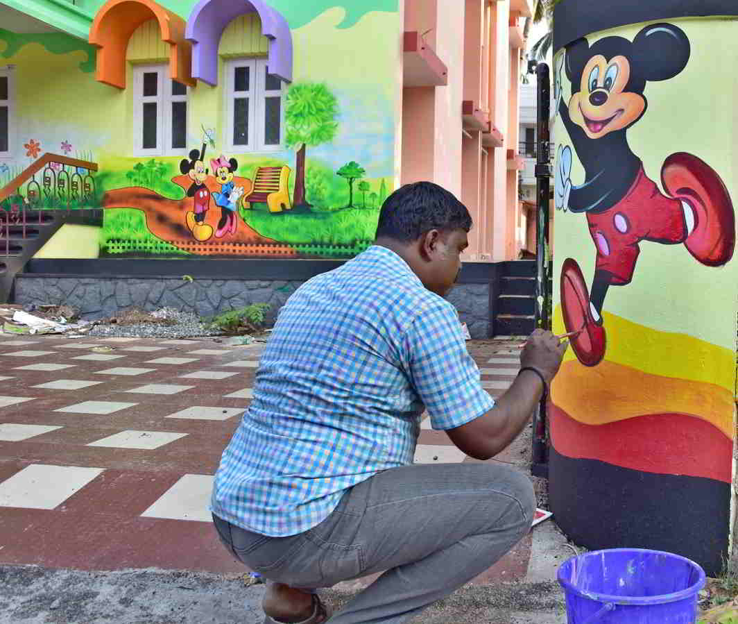 BRIGHTER, MERRIER: An artist gives finishing touches to his work on the walls of a nursery school in Thiruvananthapuram, UNI