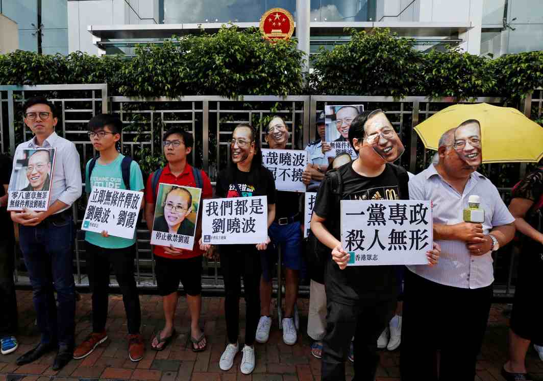 IN THEIR HEARTS: Protesters wearing masks of Chinese Nobel-winning rights activist Liu Xiaobo stand outside China's Liaison Office in Hong Kong, Reuters/UNI