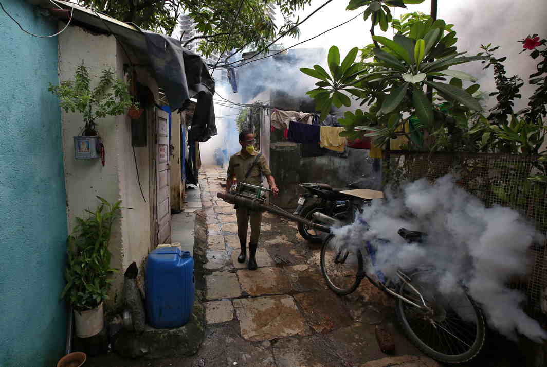 STOP THE VIRUS: A municipal worker fumigates a slum to prevent the spread of dengue and other mosquito-borne diseases in Mumbai, Reuters/UNI