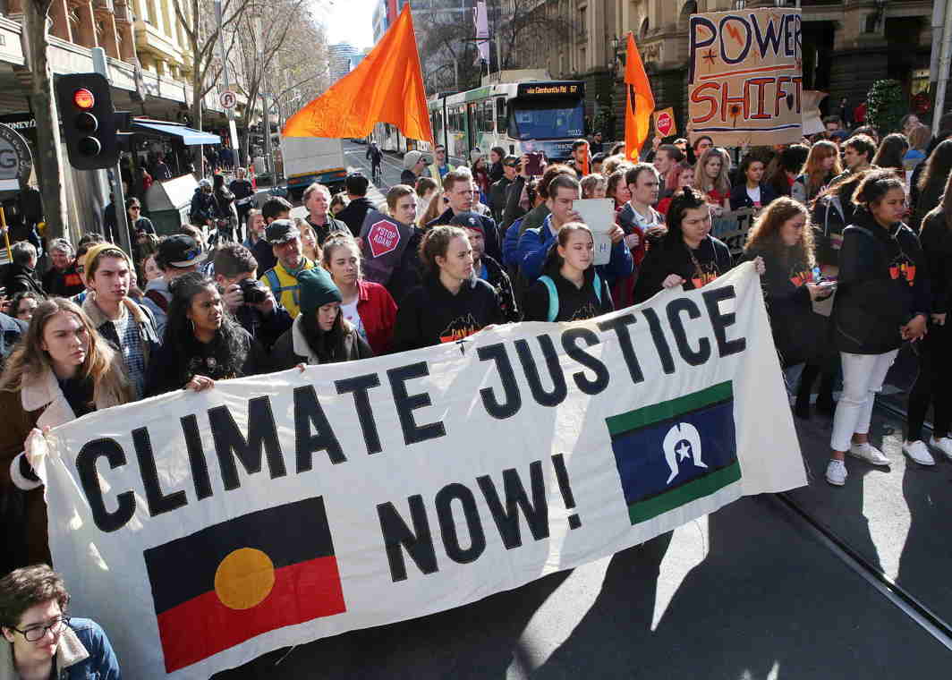 URGENT CALL: A protester waves an Australian aboriginal flag during a march calling for an end to the use of fossil fuels in central Melbourne, Reuters/UNI