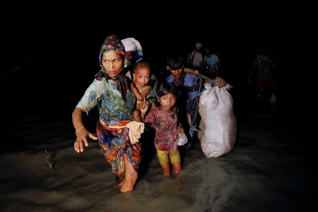 EXODUS CONTINUES: People make their way to the shore as hundreds of Rohingya refugees arrive under cover of darkness by wooden boats from Myanmar to Shah Porir Dwip, in Teknaf, near Cox's Bazar in Bangladesh, Reuters/UNI