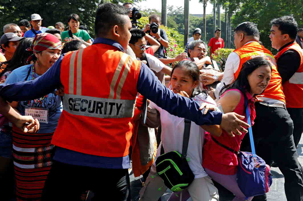 FIGHT FOR A CAUSE: Security guards block anti-mining protesters as they try to enter a hotel where the Philippines annual mining conference is held in Pasay, Metro Manila, Philippines, Reuters/UNI