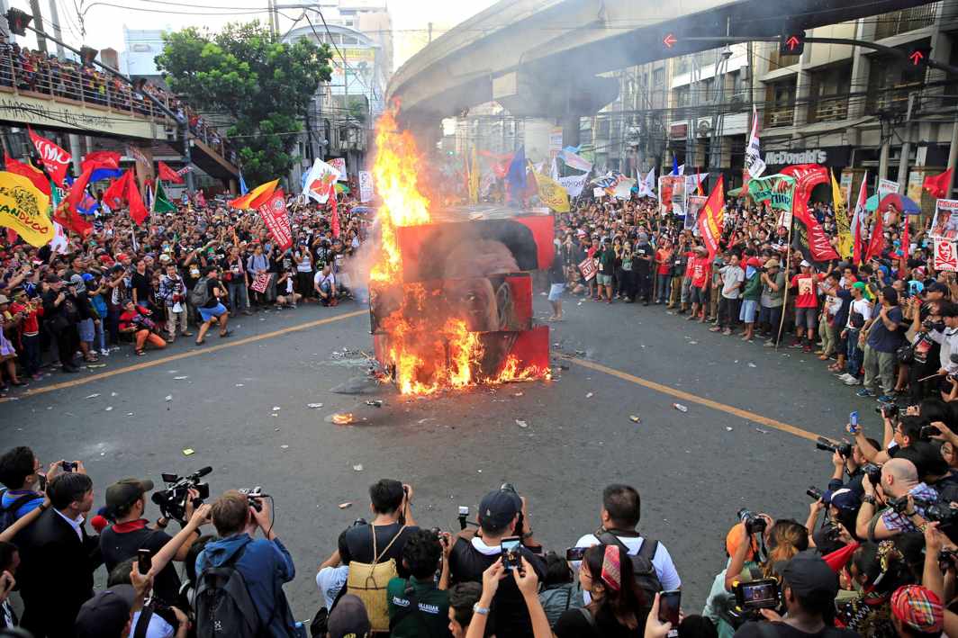 CELEBRATING DEMOCRACY: Protesters burn an effigy with the face of President Rodrigo Duterte during a National Day of Protest outside the presidential palace in Manila, Philippines, Reuters/UNI