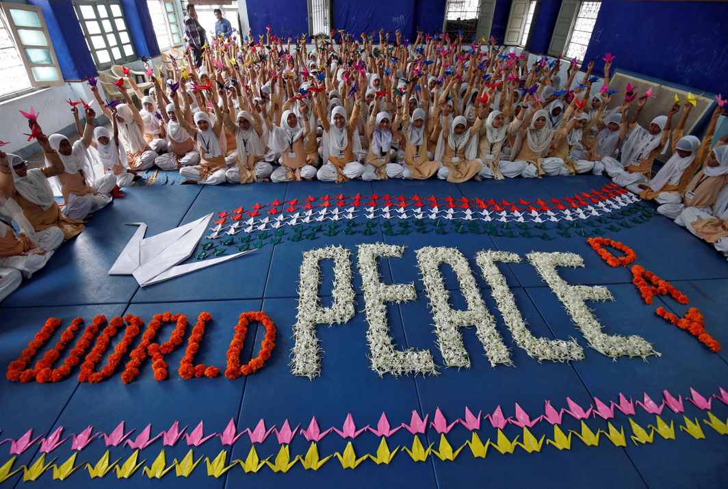 PLAY OF SYMBOL: Students hold paper cranes during a ceremony to mark International Peace Day in Ahmedabad, Reuters/UNI