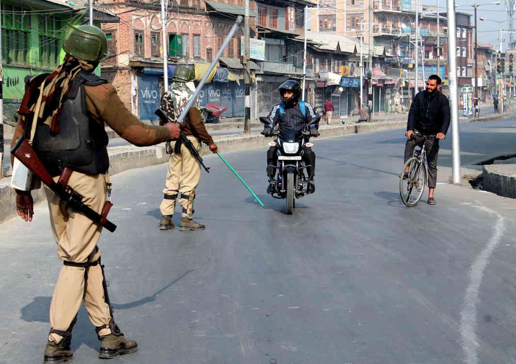 THIS WAY: Security personnel direct commuters to take another route at Gojiwara amid curfew-like restrictions imposed by the authorities in downtown and Shehar-e-Khas besides parts of the civil lines in Srinagar to prevent any violence following a general strike call issued by separatists in Kashmir valley, UNI
