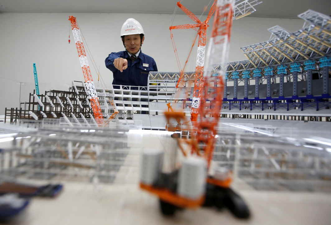 HOW TO RAISE BUILDINGS: Japan Sport Council director Yukio Komatsu gives a briefing on the construction process of New National Stadium, the main stadium of Tokyo 2020 Olympics and Paralympics, next to its 1/150 scale stadium miniature, during a media opportunity in Tokyo, Japan, Reuters/UNI
