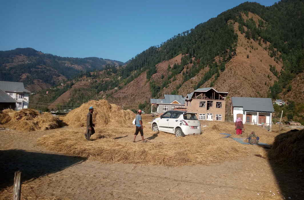 PUT TO WORK: Farmers use a Maruti Swift for threshing paddy at Sungle village in Bhaderwah valley in Jammu and Kashmir, UNI