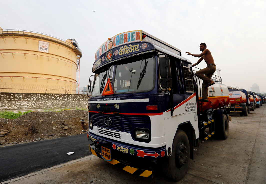 HERE WE GO: A man climbs an oil tanker parked outside a fuel depot in Mumbai, India, Reuters/UNI