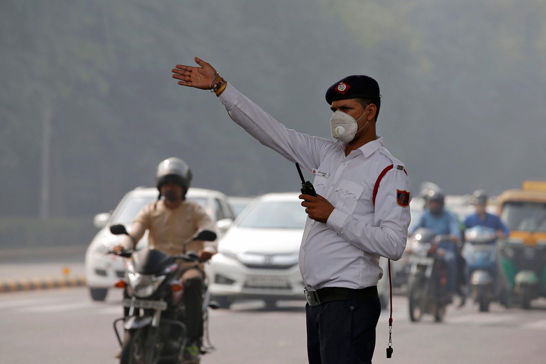 A traffic policeman wearing a mask controls the traffic at a busy road on a smoggy morning in New Delhi, Reuters/UNI
