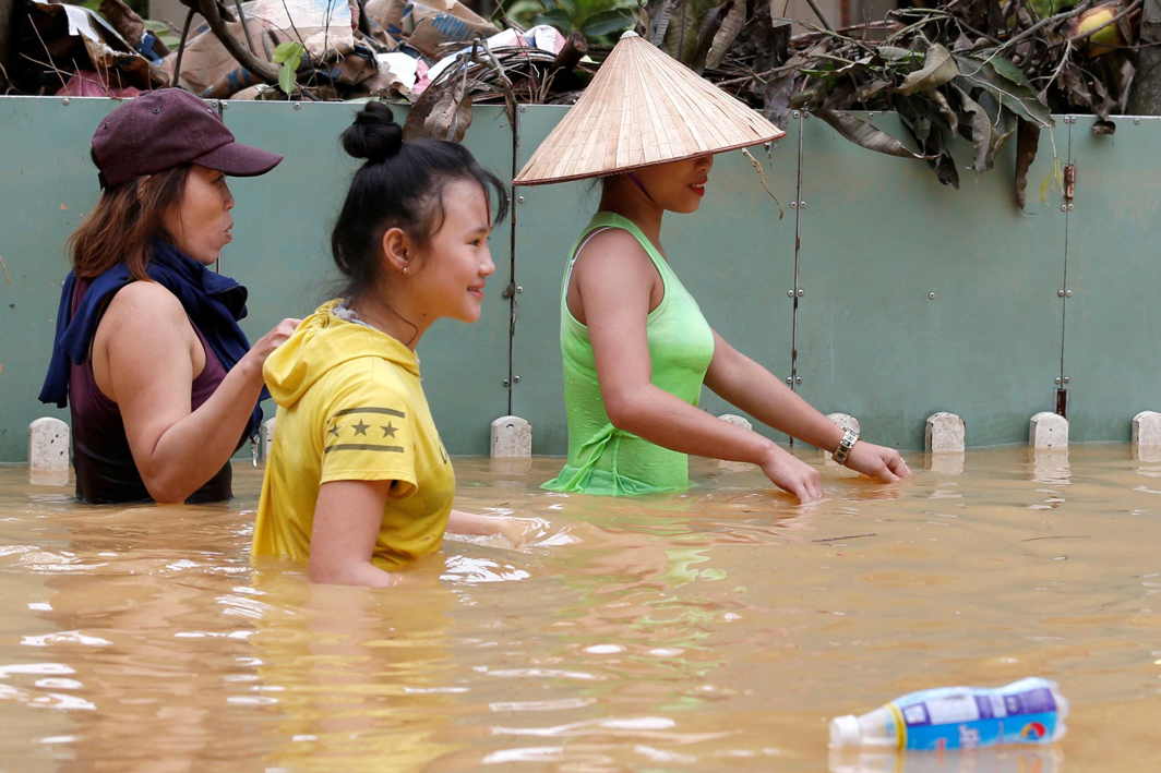 IN GOOD SPIRITS STILL: Women wade through floodwaters brought by Typhoon Damrey in the ancient UNESCO heritage town of Hoi An, Vietnam, Reuters/UNI