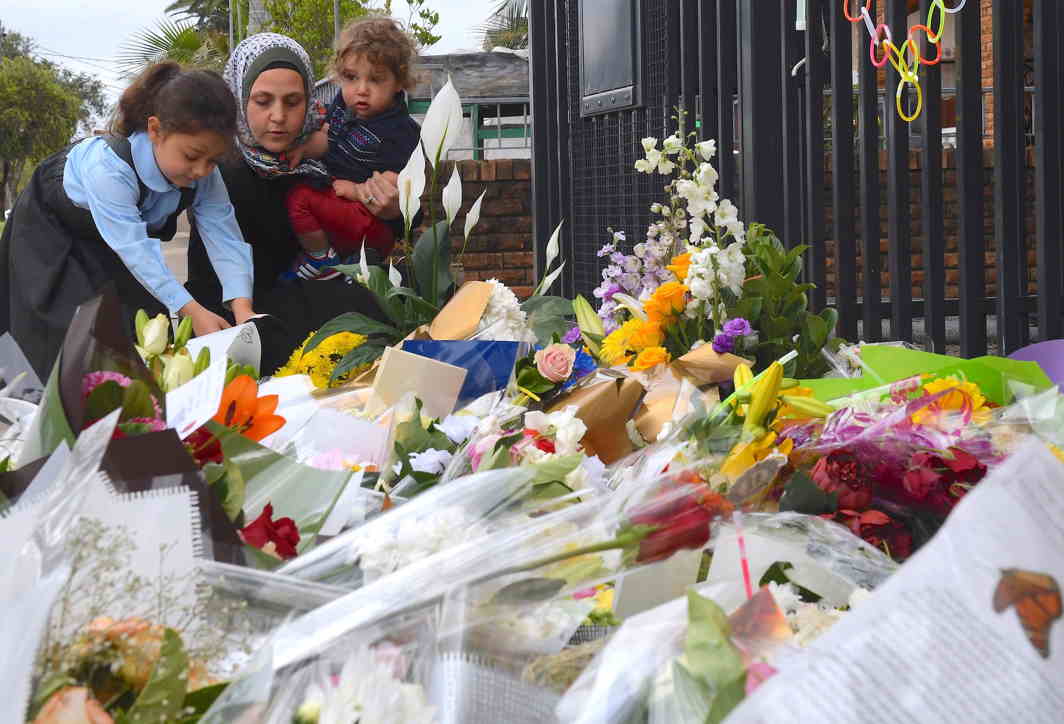 SENSELESS TRAGEDY: A mother and her young children place flowers outside the gates of the Banksia Road Public School, the day after a vehicle crashed into one of the primary school's classroom killing two children, in the Sydney suburb of Greenacre in Australia, Reuters/UNI