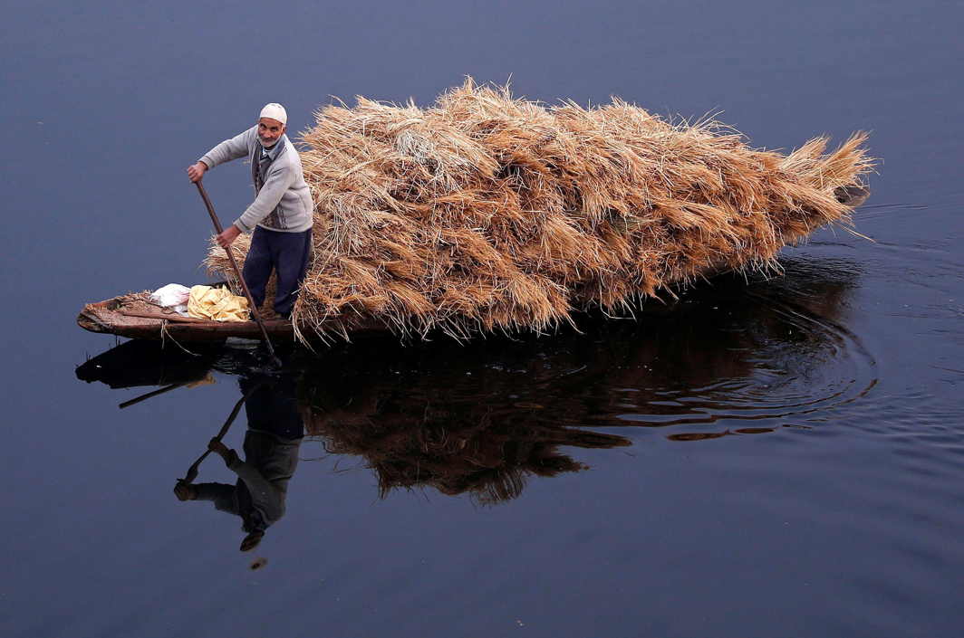 WET TRANSPORT: A man rows his boat filled with straw on the waters of Nageen Lake on a cold morning in Srinagar, Reuters/UNI