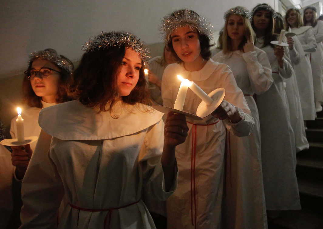 LET THERE BE LIGHT: Youths light candles as they wait to perform during the celebration of St Lucia's Day at the Swedish Evangelical and Lutheran church of St Katarina in St Petersburg, Russia, Reuters/UNI