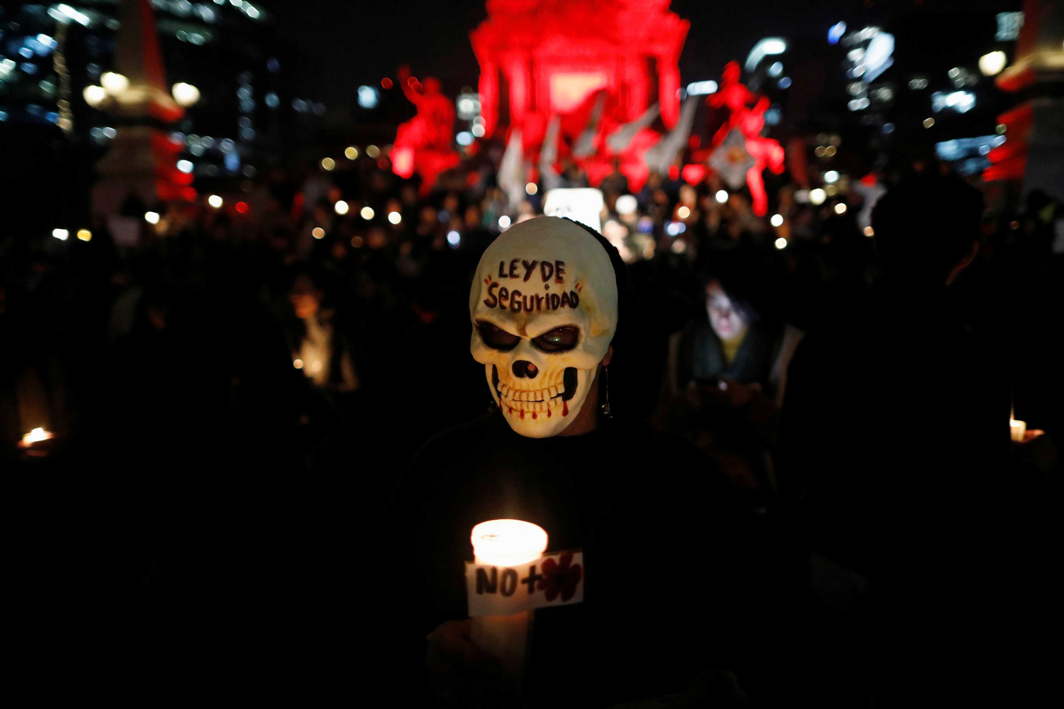 CONTROVERSIAL LAW: An activist in a mask holds a candle during a protest against a new security bill, Law of Internal Security, in Mexico City, Reuters/UNI