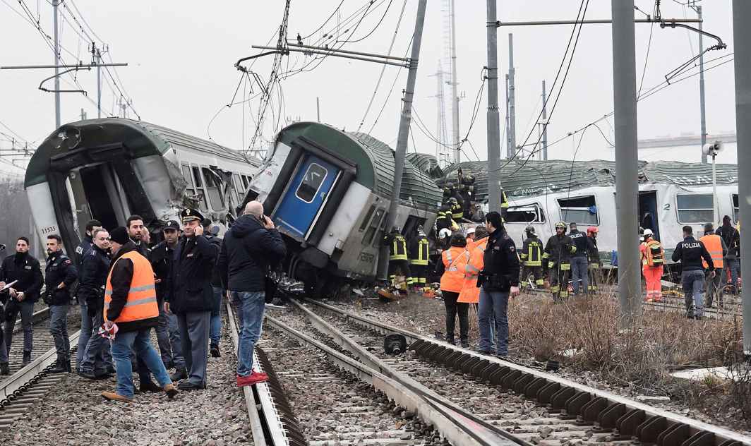SITE OF MISHAP: Rescue workers and police officers stand near derailed trains in Pioltello, on the outskirts of Milan, Italy. At least two people were killed in the accident, Reuters/UNI