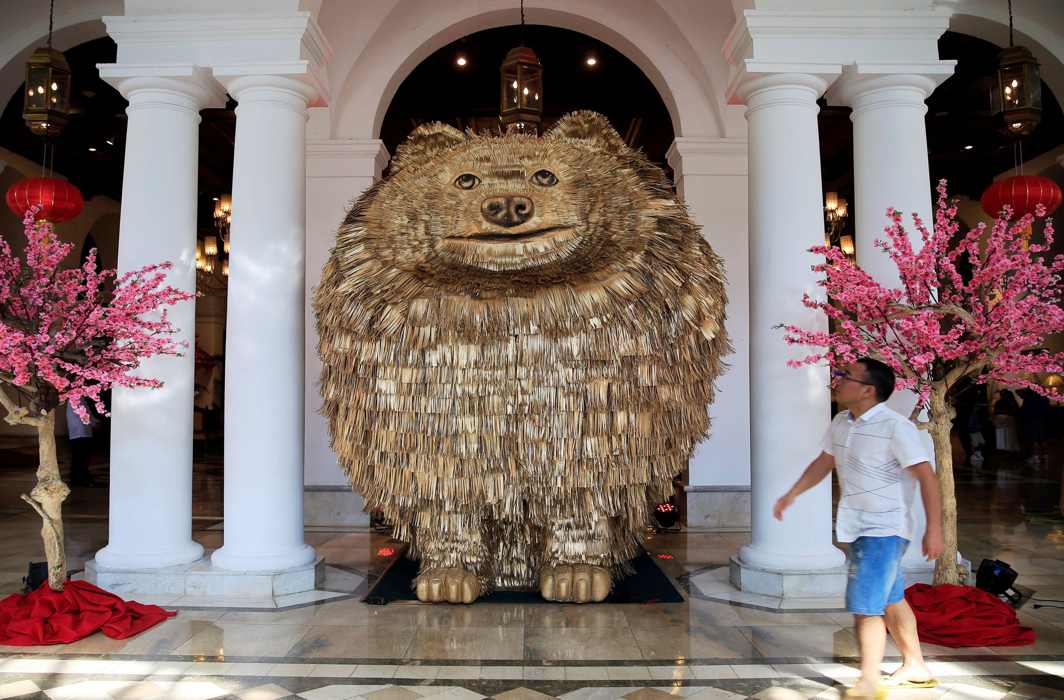 LARGER THAN LIFE: A hotel guest looks at a Pomeranian dog-shaped statue displayed at a hotel, ahead of the Chinese Lunar New Year of the Dog in Metro Manila, Philippines, Reuters/UNI